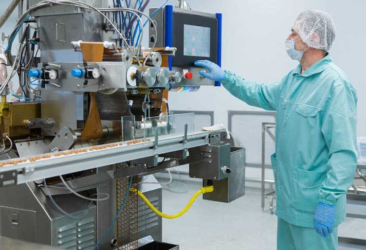 Operator monitoring a production line control interface.