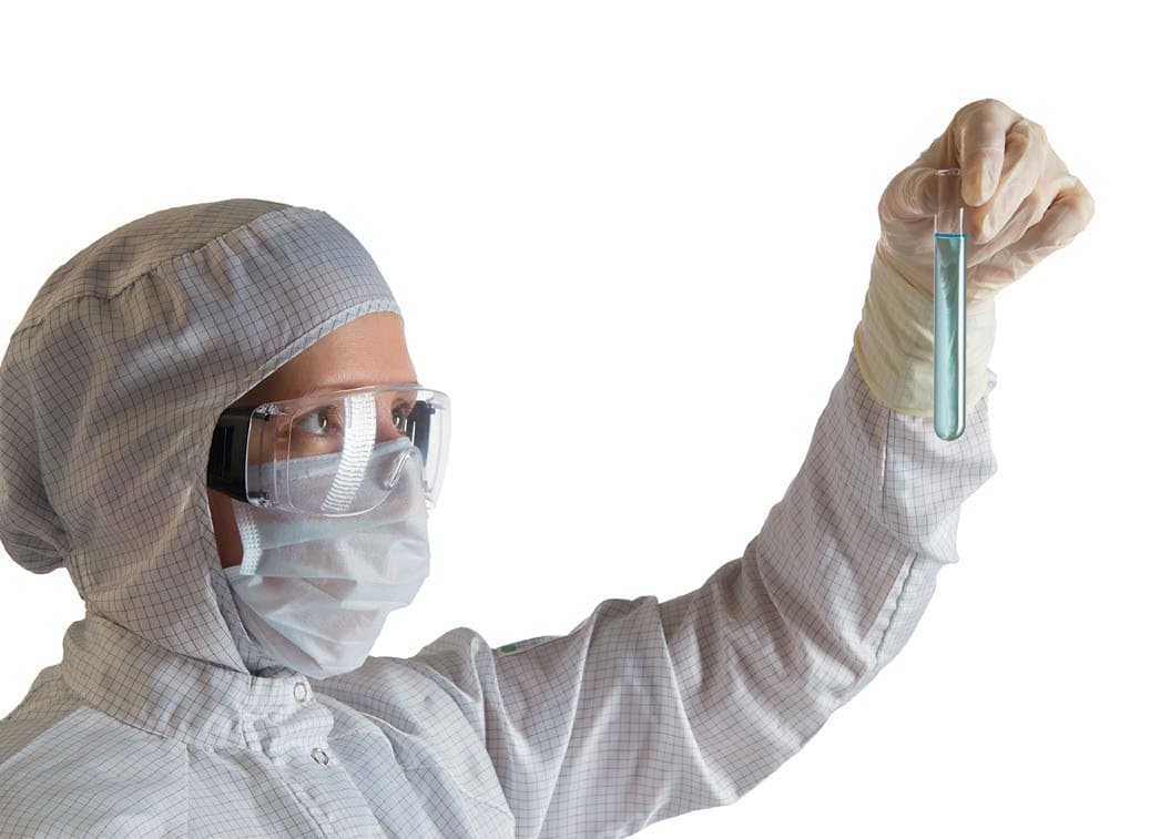 Technician inspecting a sample in a controlled laboratory setting.