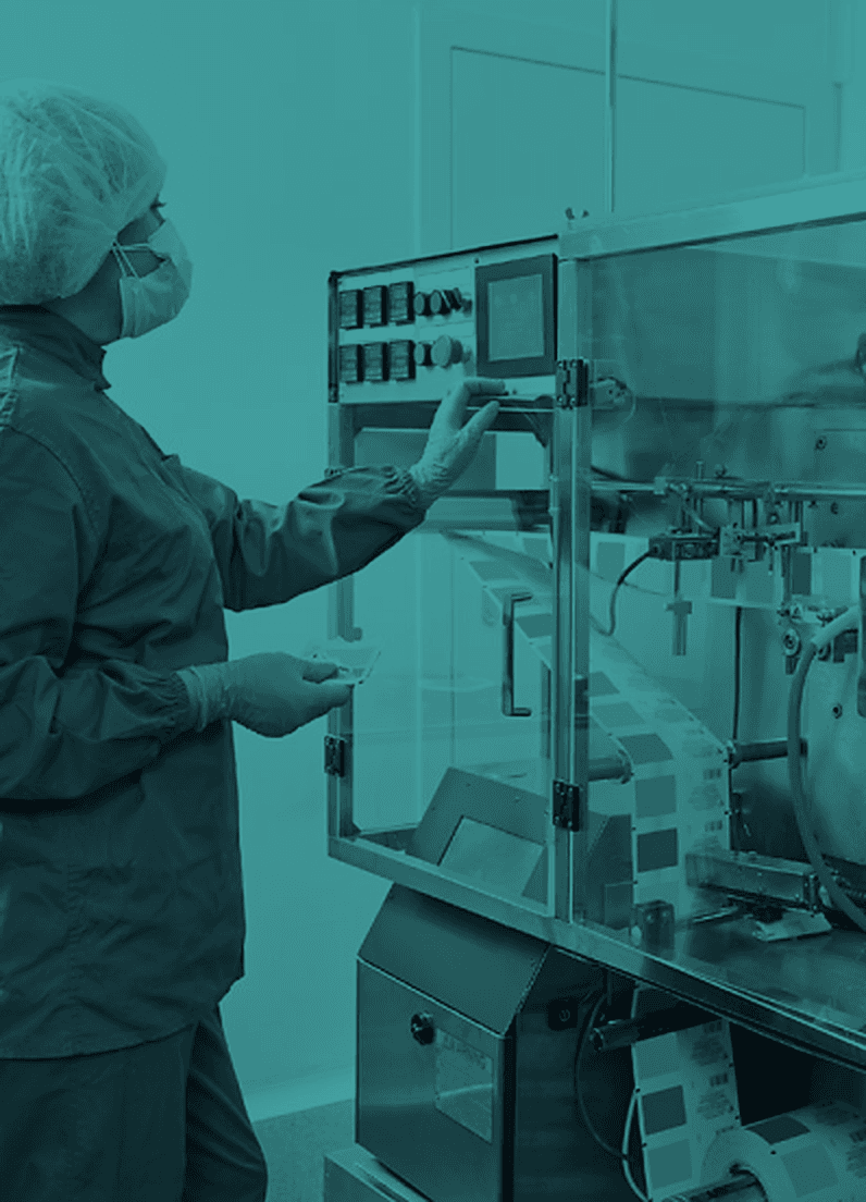 Jamjoom production operator standing beside manufacturing equipment.